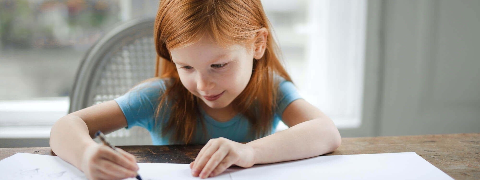 Little red-head girl writing