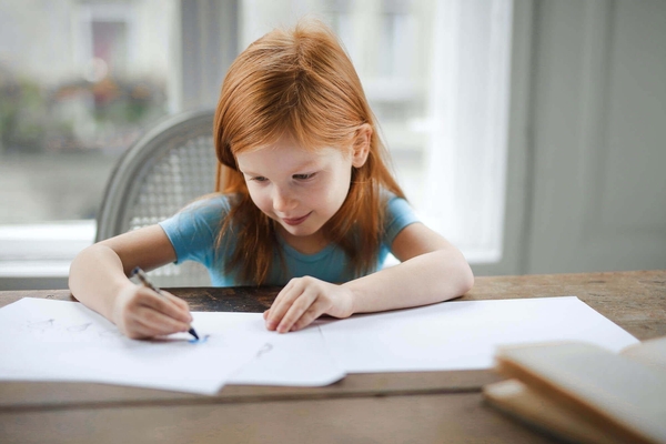 Girl writes at desk